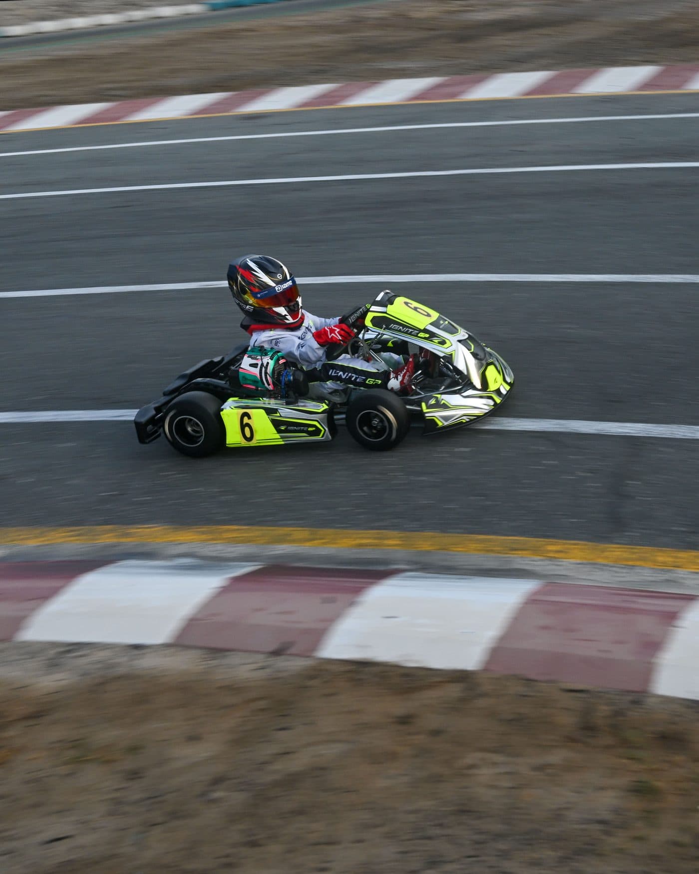 Bambino kart through a fast corner, kerbs and run-off filling the frame
