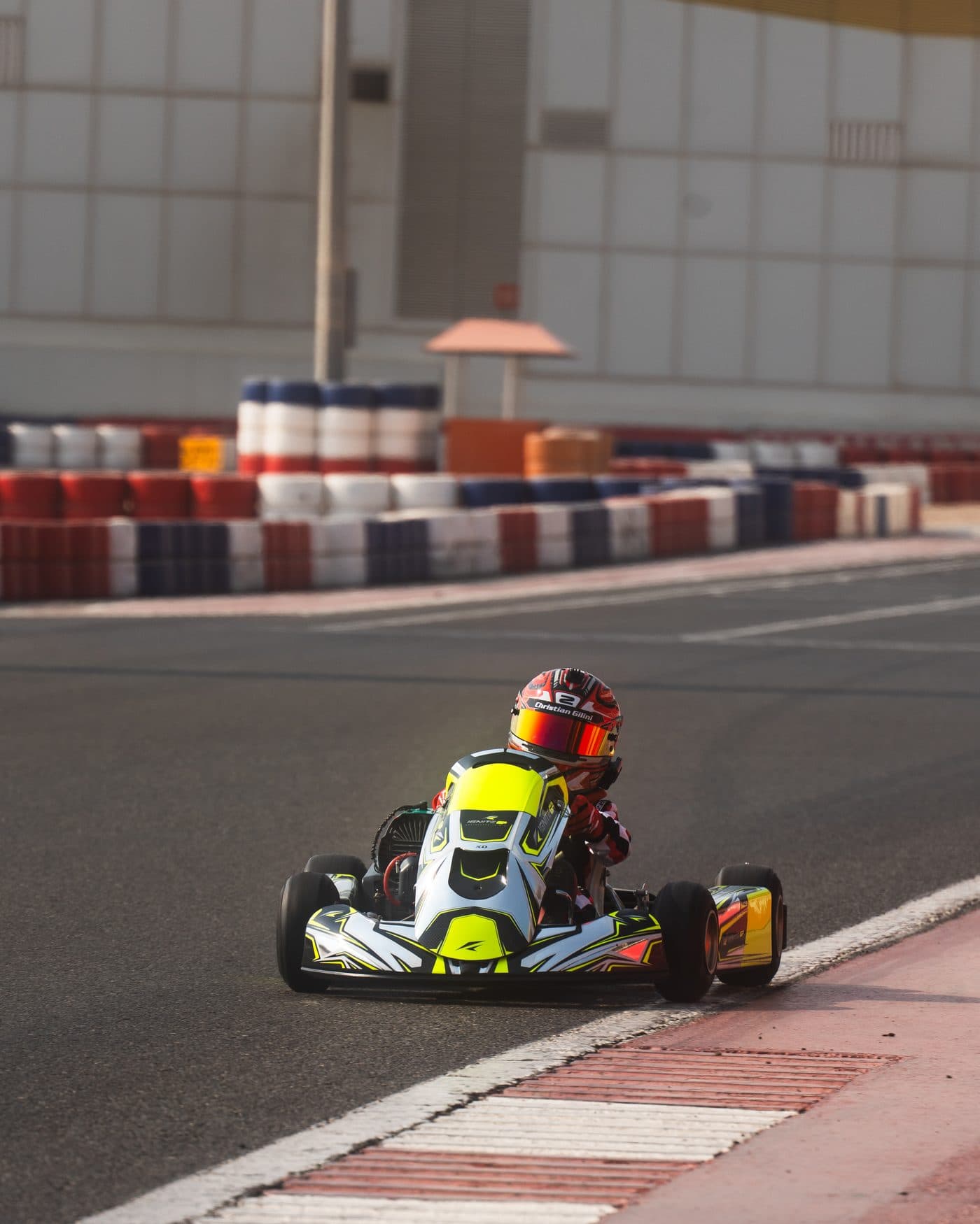Bambino driver on the main straight at Dubai Kartdrome, kart heading towards the camera past the barriers