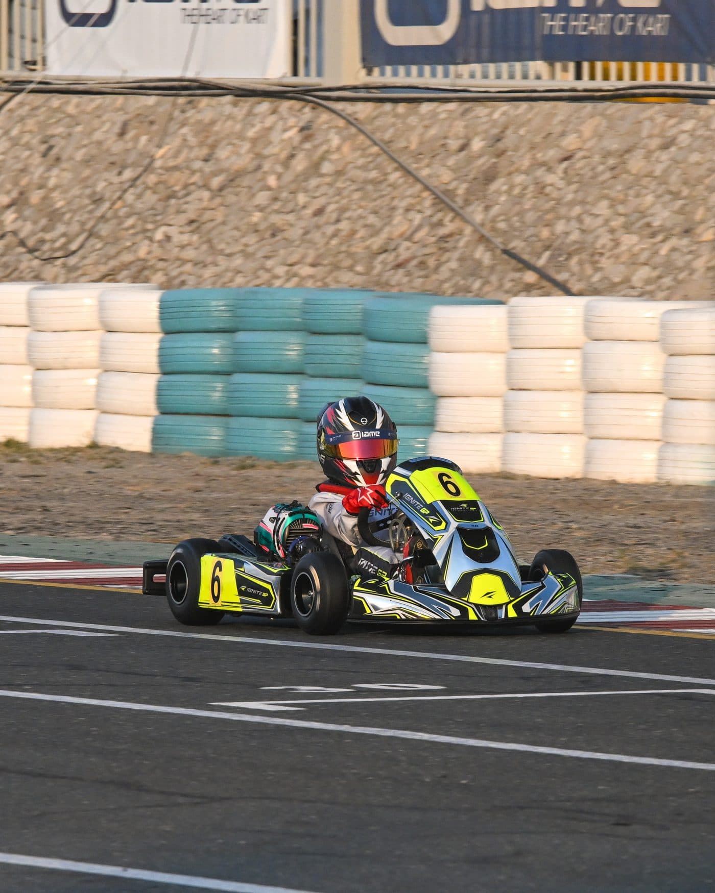Bambino driver crossing the line in front of the tyre wall and the circuit banners