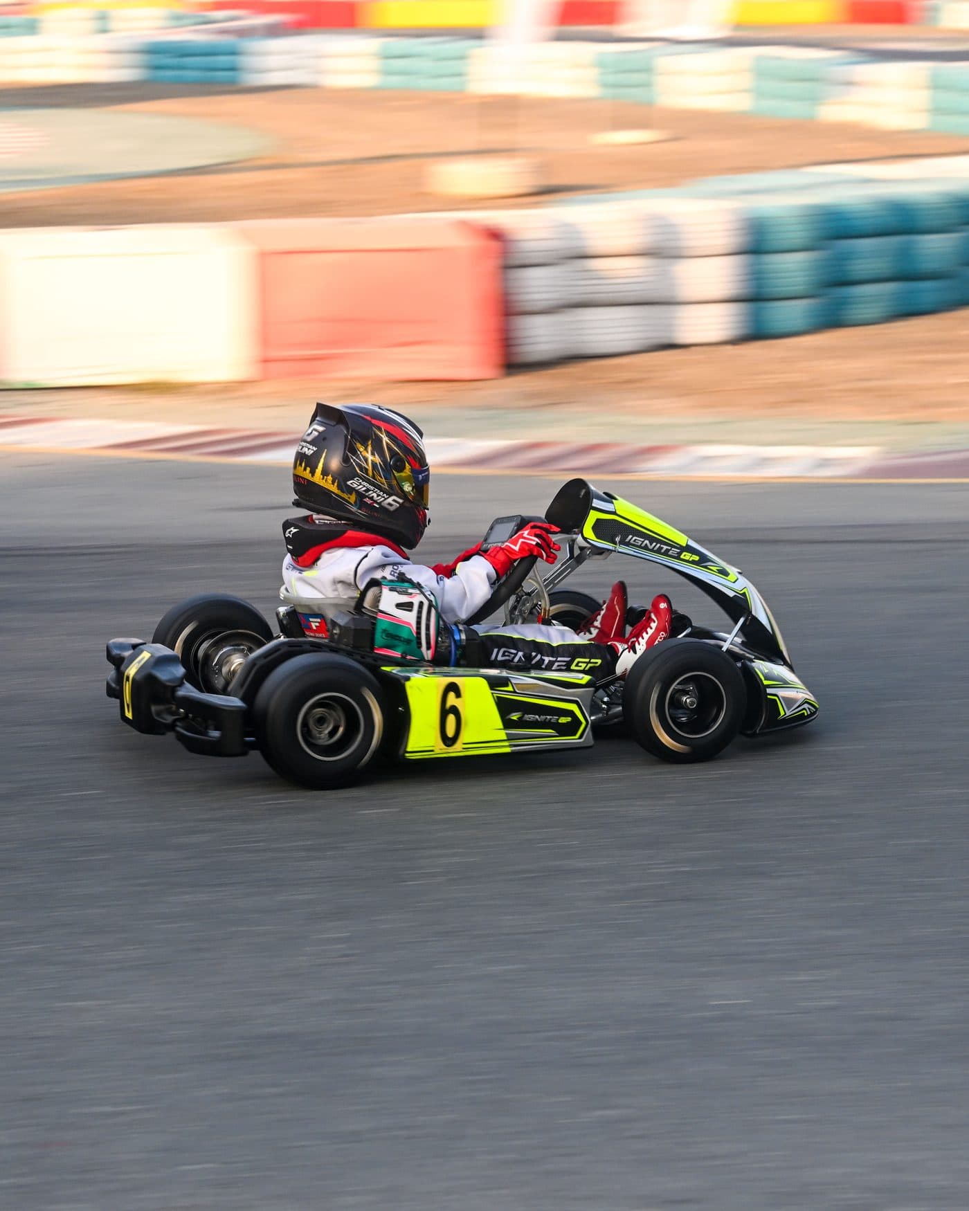 Bambino kart panned at speed in golden evening light, the barriers blurring behind
