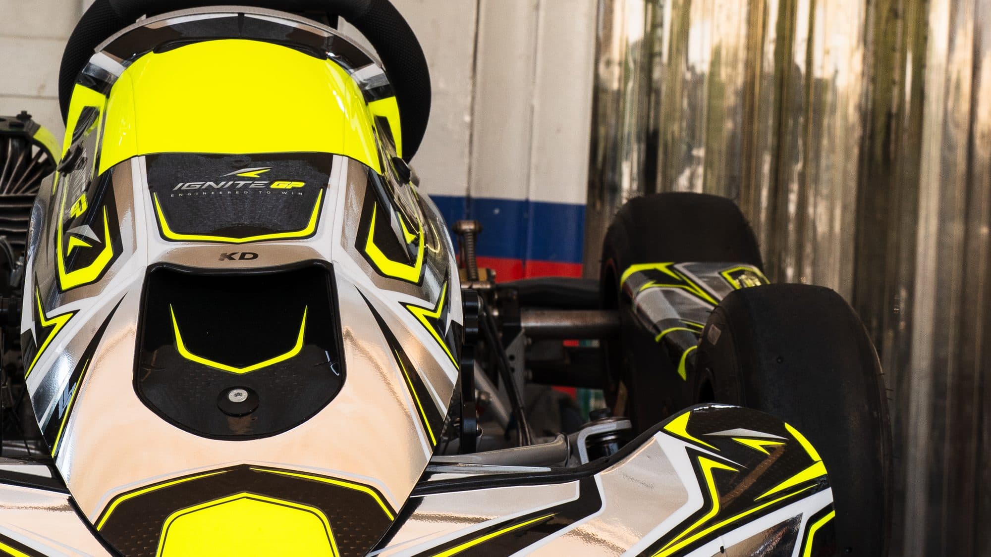 Ignite GP Bambino kart on a stand in the workshop, nose towards the camera, 'Engineered to win' on the nassau panel