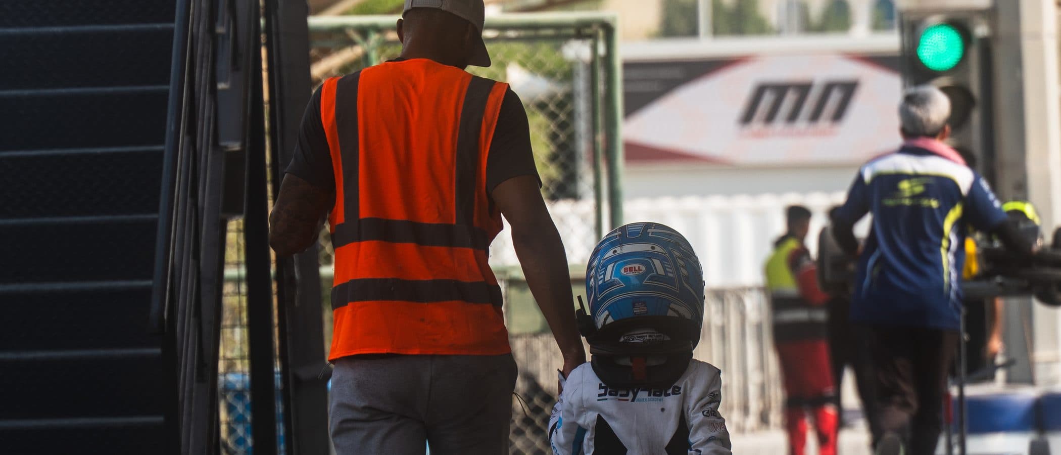 Ignite GP coach walking hand in hand with a young driver through the paddock