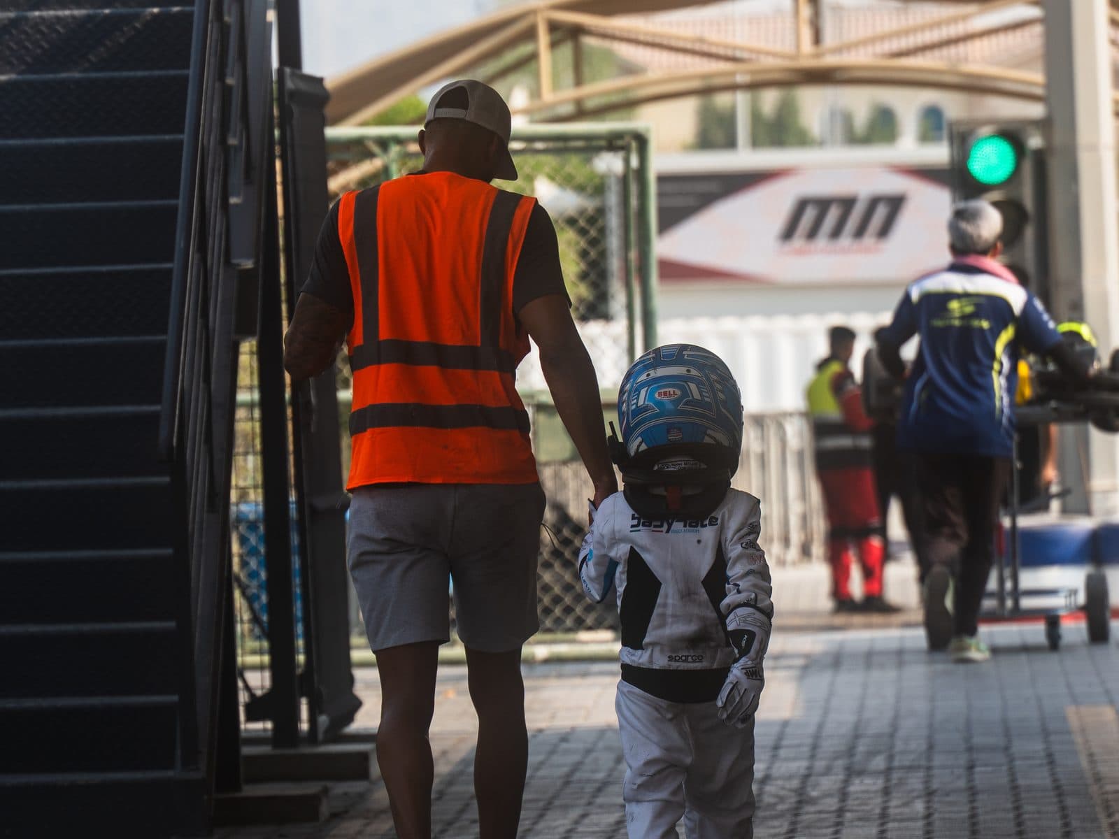Ignite GP coach walking hand in hand with a young driver through the paddock