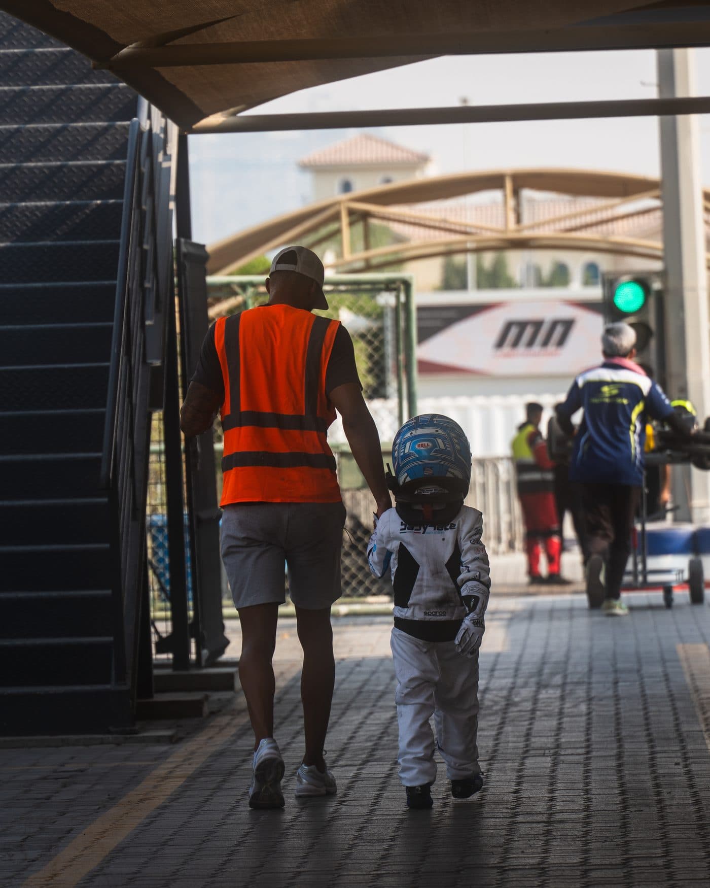 Ignite GP coach walking hand in hand with a young driver through the paddock